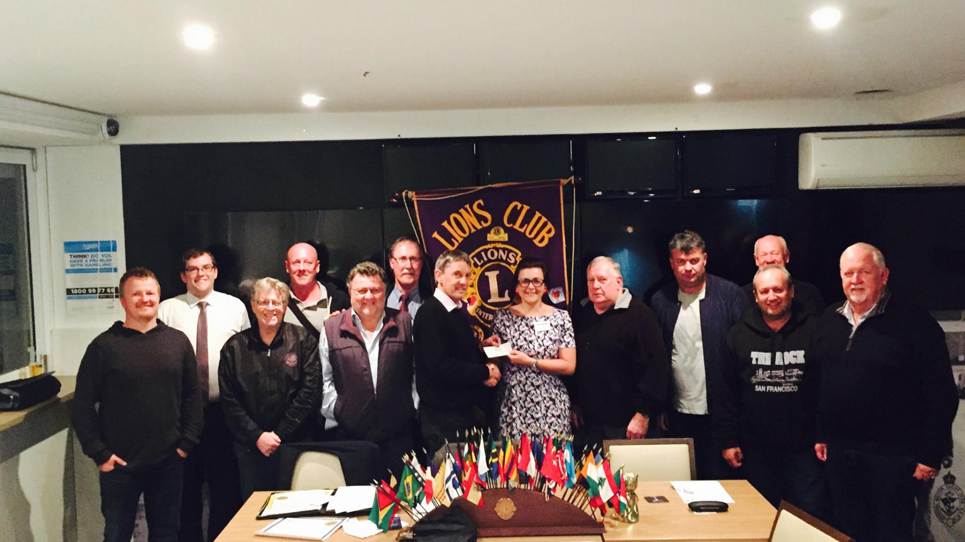 Modern white house with a lush green garden, featuring a stone pathway and large trees in a sunny setting.