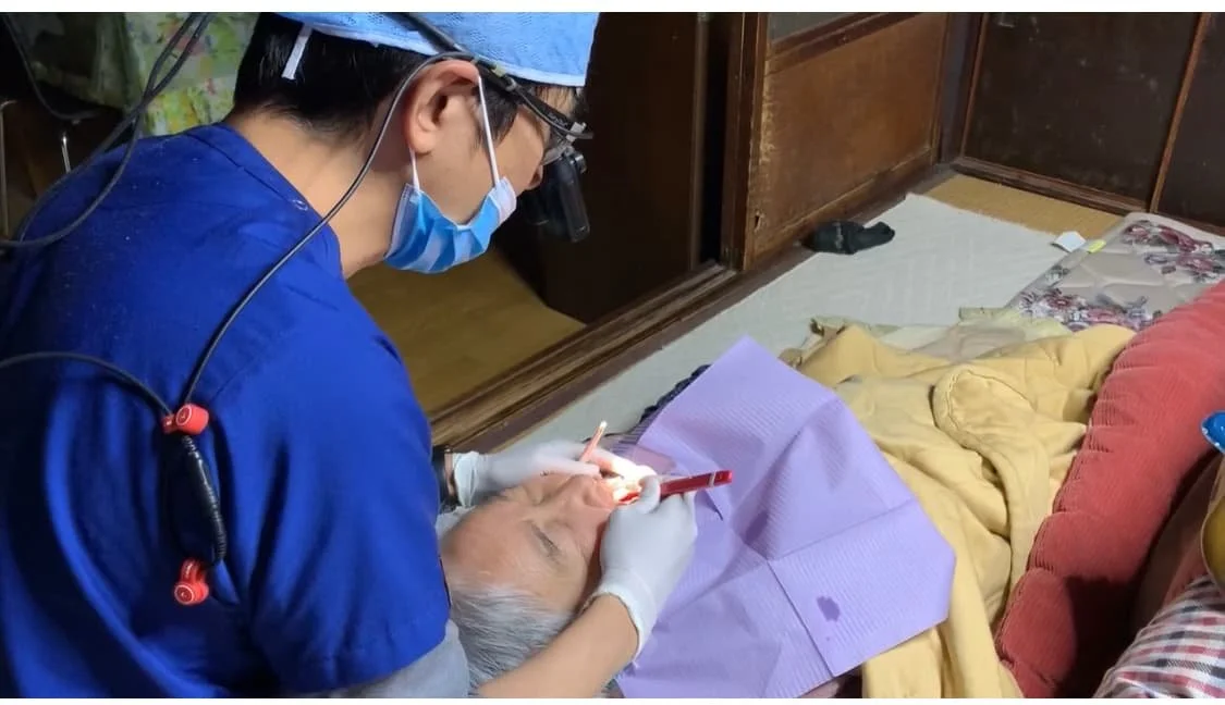 歯医者が高齢の患者の歯を診察している