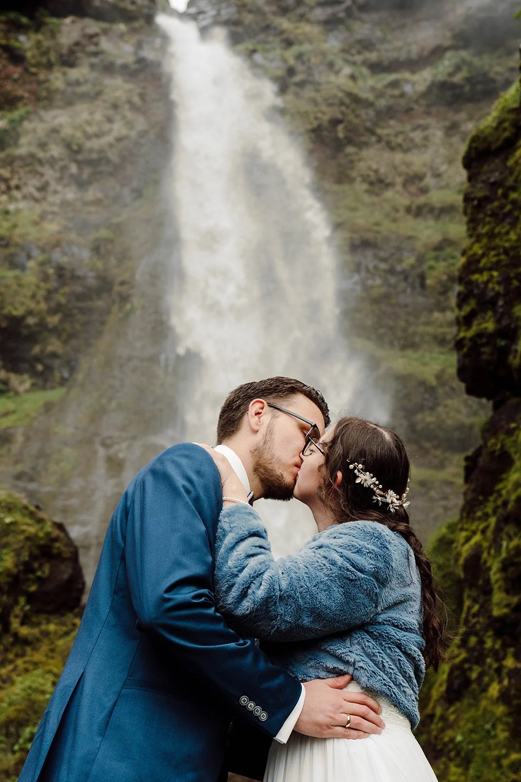 Bride and groom kissing under a waterfall during their Iceland elopement