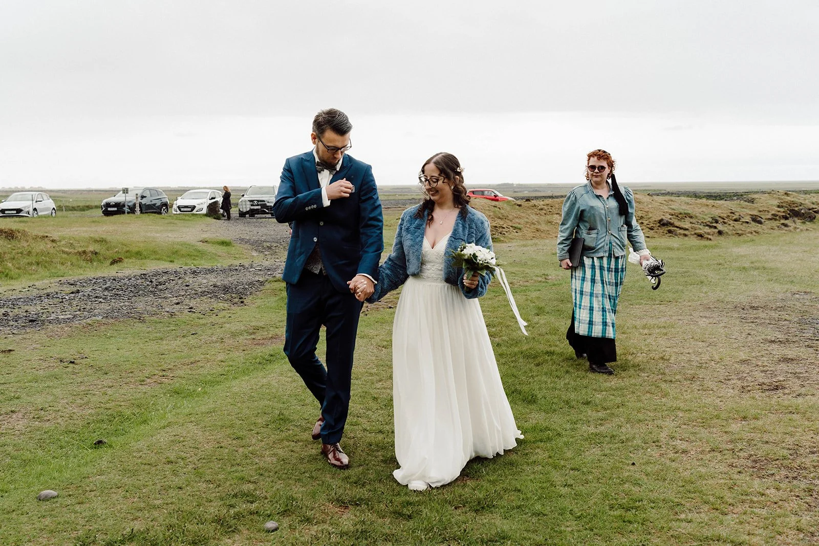 Bride and groom walking hand in hand to their outdoor elopement ceremony in Iceland