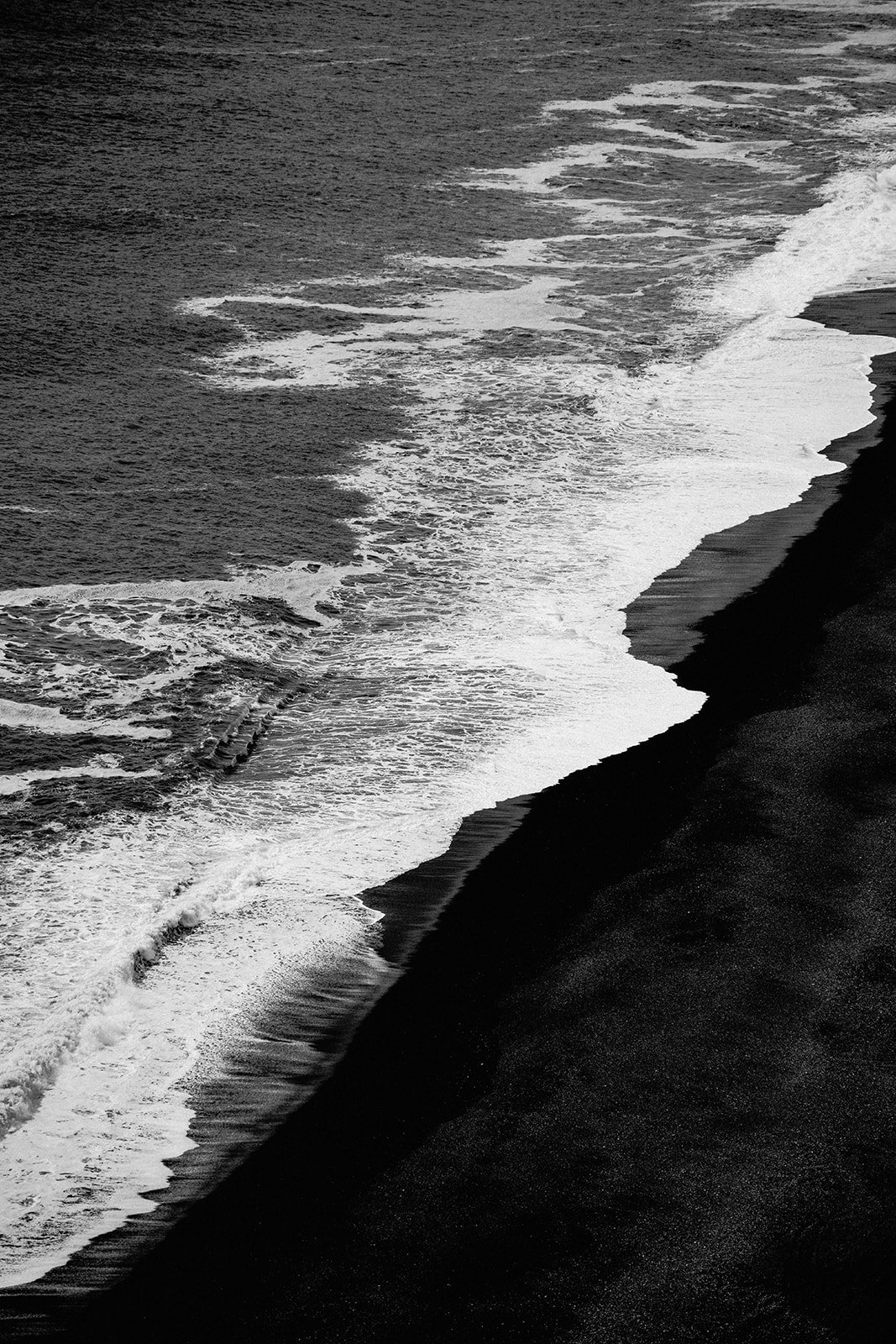 Black and white photo of waves on Iceland’s black sand beach