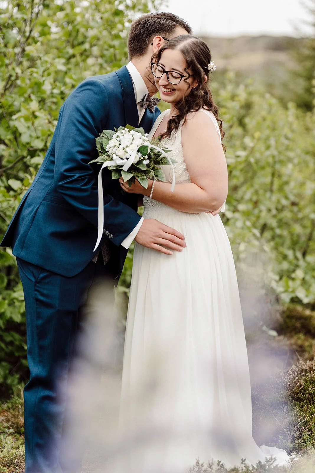 Intimate moment between bride and groom holding a bouquet during their Iceland elopement in nature