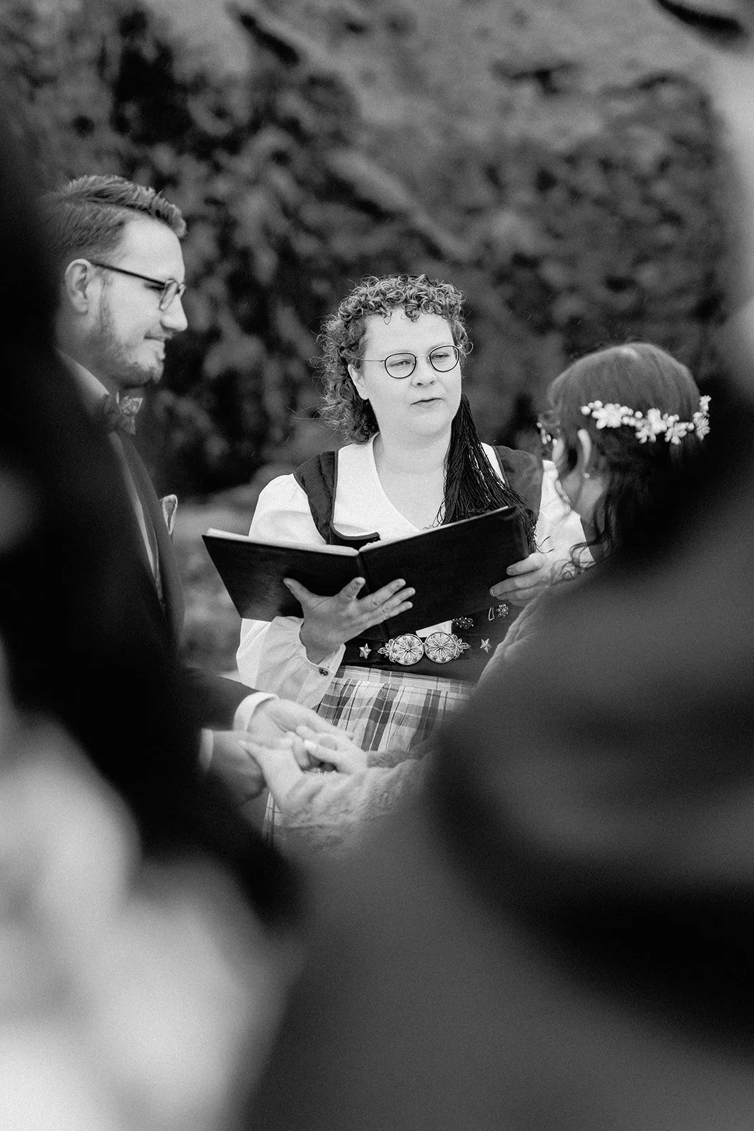 Black and white photo of an intimate elopement ceremony with officiant reading vows in Iceland