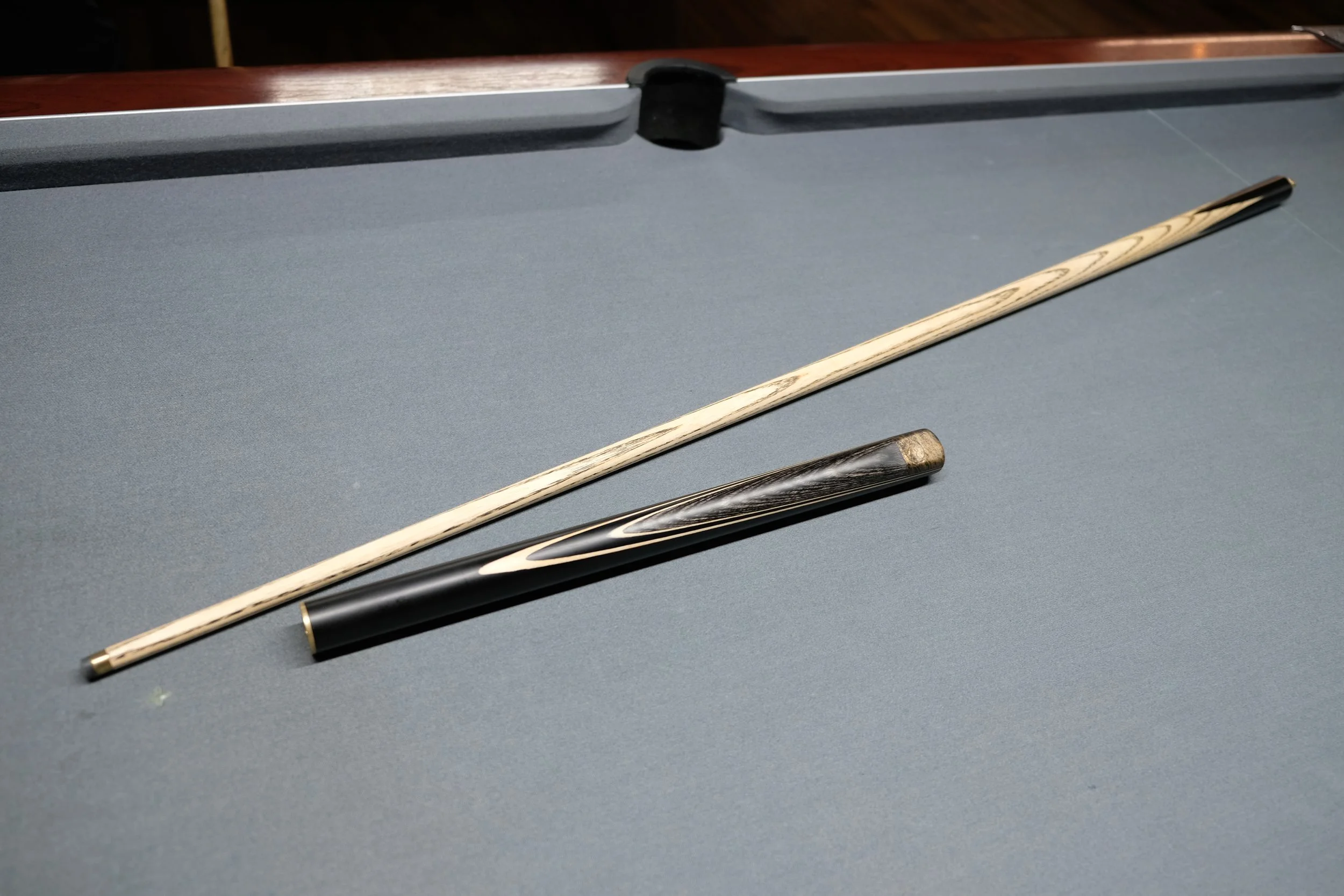 Pool cue stick and cue tip on a pool table.