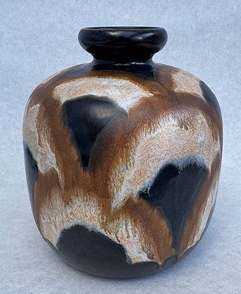 Vase de verre opaque avec motifs floraux en relief, éclairé de l'intérieur avec une lumière chaude, créant un effet lumineux avec des ombres de feuilles et de fleurs sur la surface.