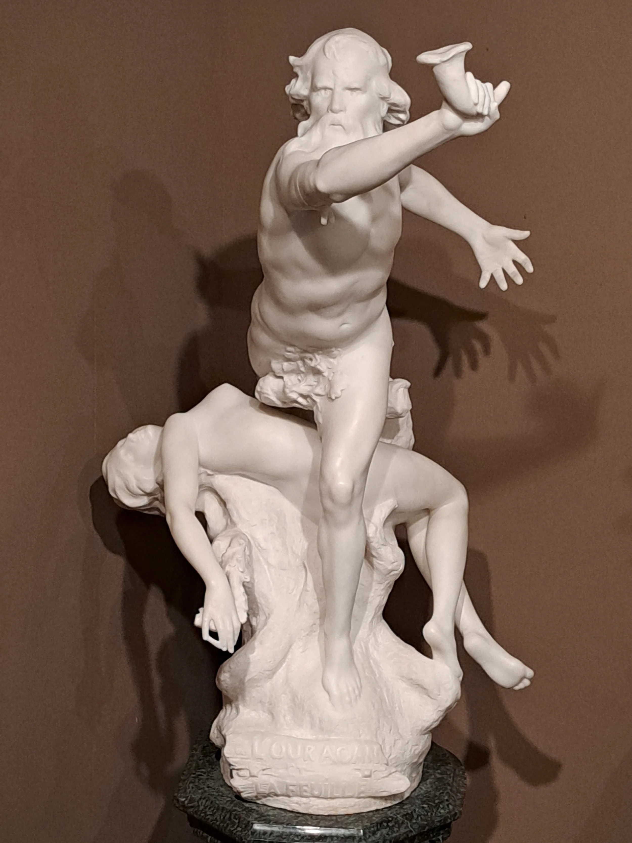 Deux candélabres ornementaux en or, avec des enfants en or sculptés, posés sur une surface en marbre.