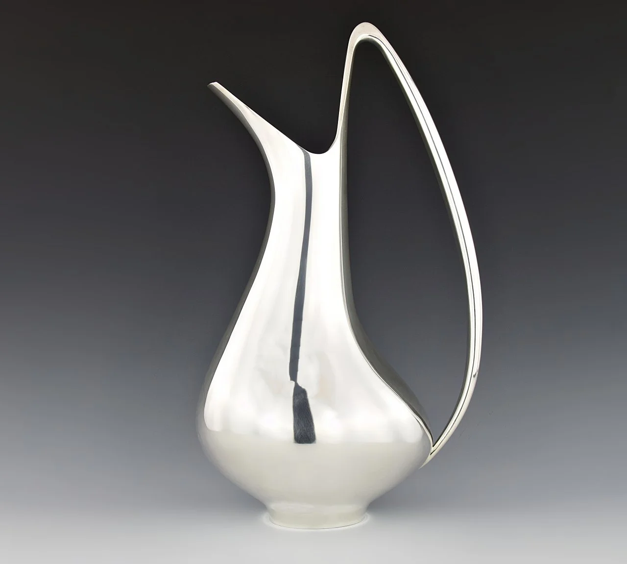 Groupe de trois pièces métalliques en forme de chapeaux de fête, en acier inoxydable, avec un des objets ayant une poignée, un autre un cône avec un sommet en aluminium, et le troisième aussi en forme de cône, disposés sur un fond dégradé gris.