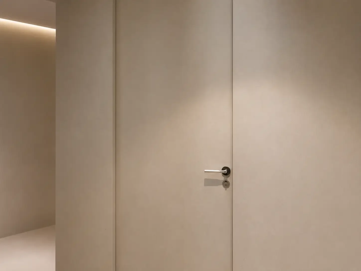 Close-up of a seamless microcement wall and door finish in a Singapore apartment.