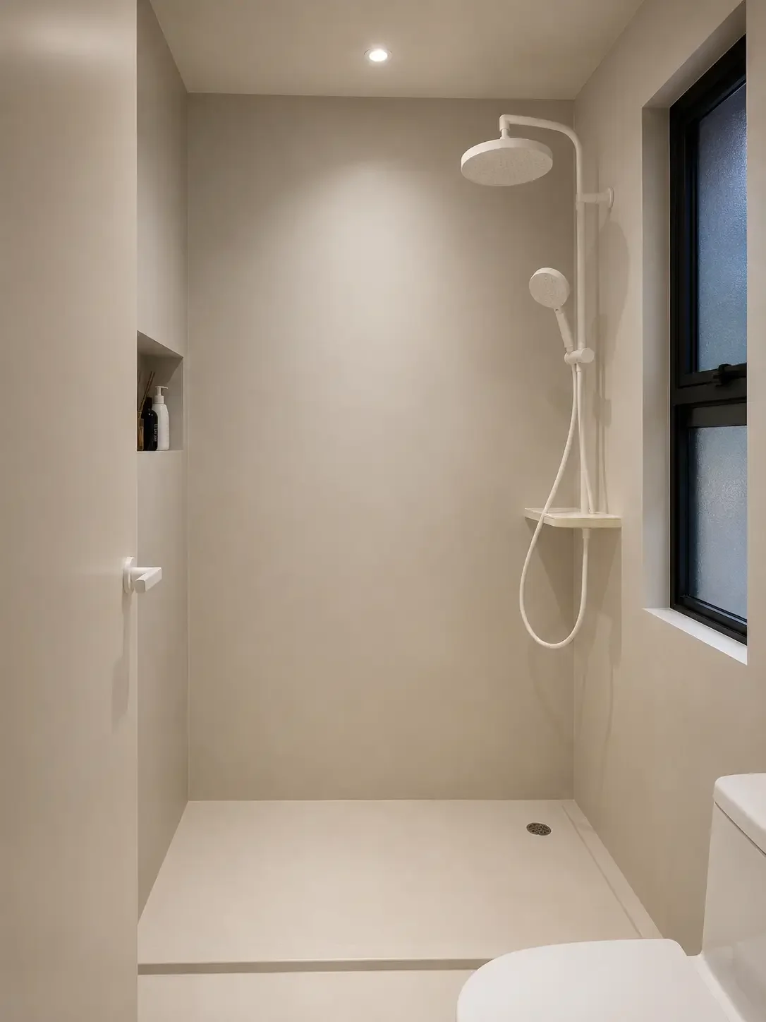 Microcement shower area in a Singapore bathroom with seamless wall and floor finish.