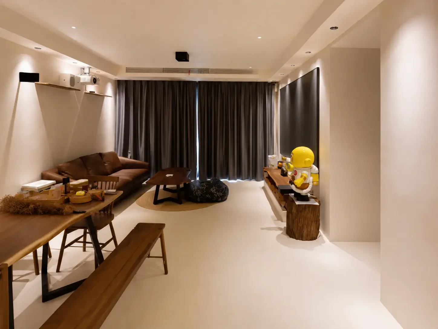 Singapore apartment living room with seamless light beige microcement flooring and curved sofa.
