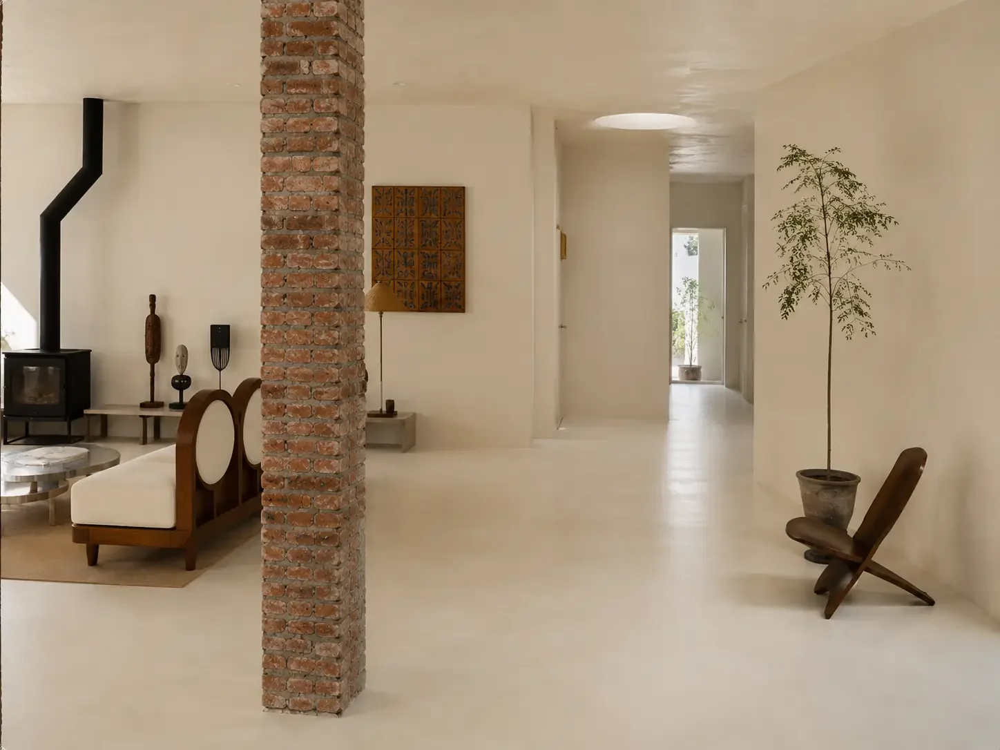 Light microcement hotel interior with exposed brick column and sculptural seating in China.