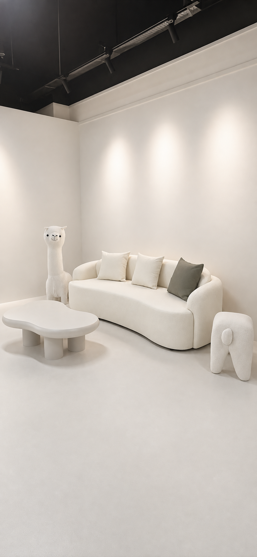 Curved cream sofa and rounded coffee table with light-toned seamless finishes in the Semiforêt showroom.