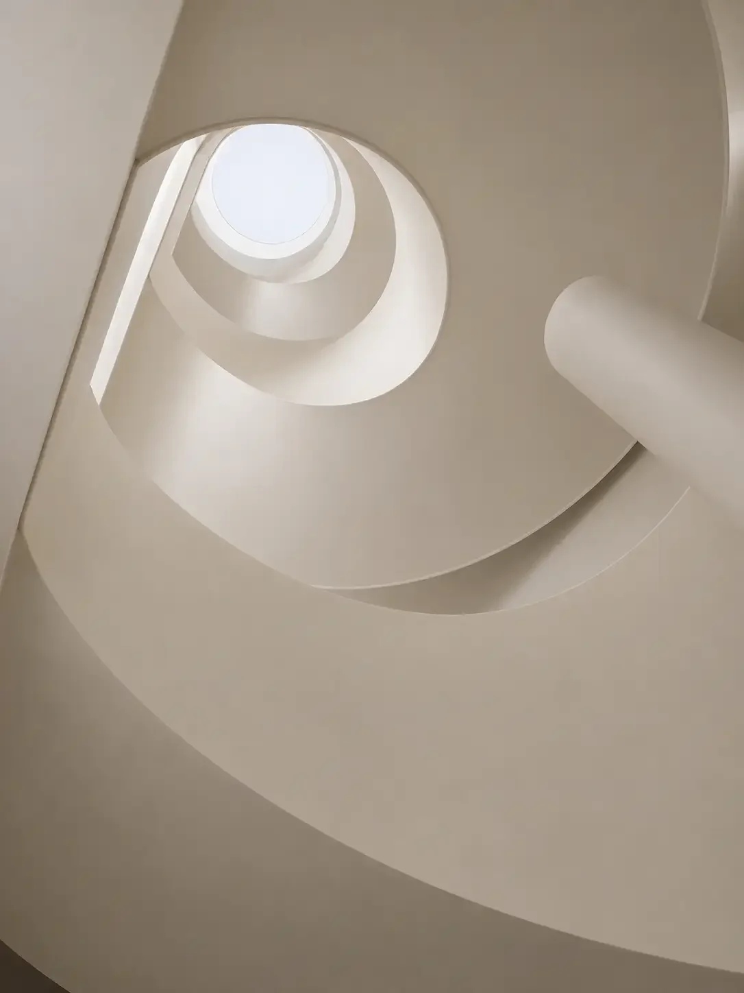 Spiral staircase detail with smooth microcement surfaces in a China villa.