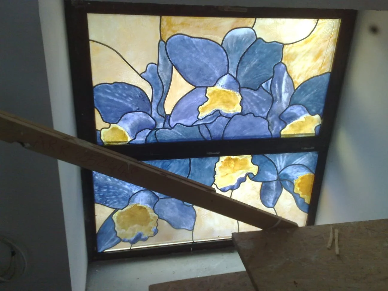 Stained glass window featuring blue and yellow iris flowers.