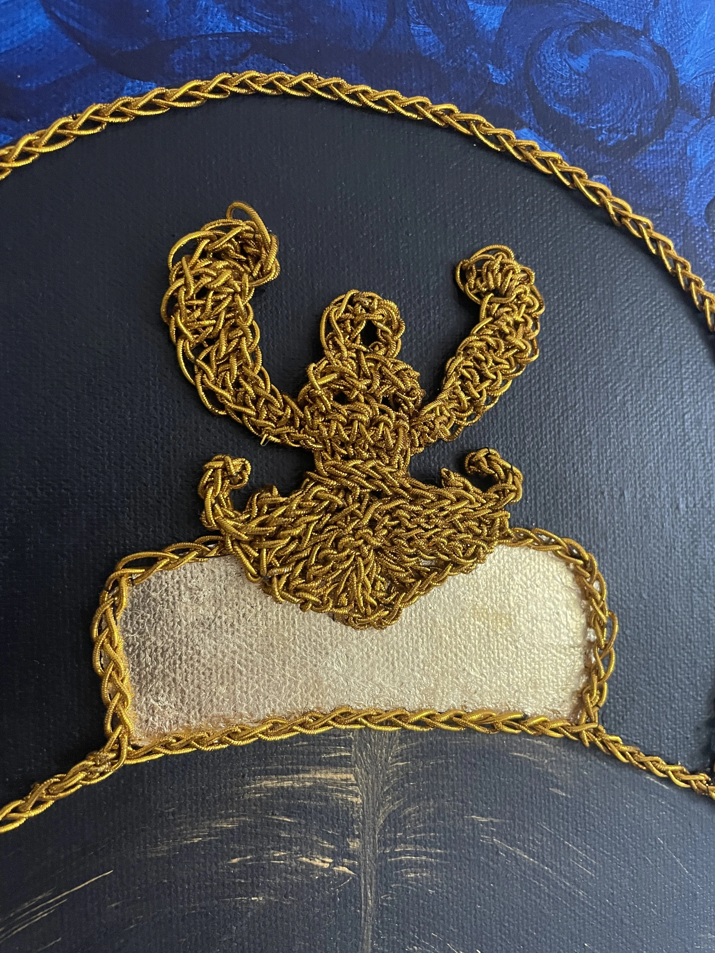 Symbolic details: the Scythian Goddess Api (hand-crocheted), crowned atop the hair. Api is the daughter of the Borysthenes (Dnipro) and the Scythian foremother. Uniting Earth and Water, she represents the origin of life. Her raised, wing-like arms sy