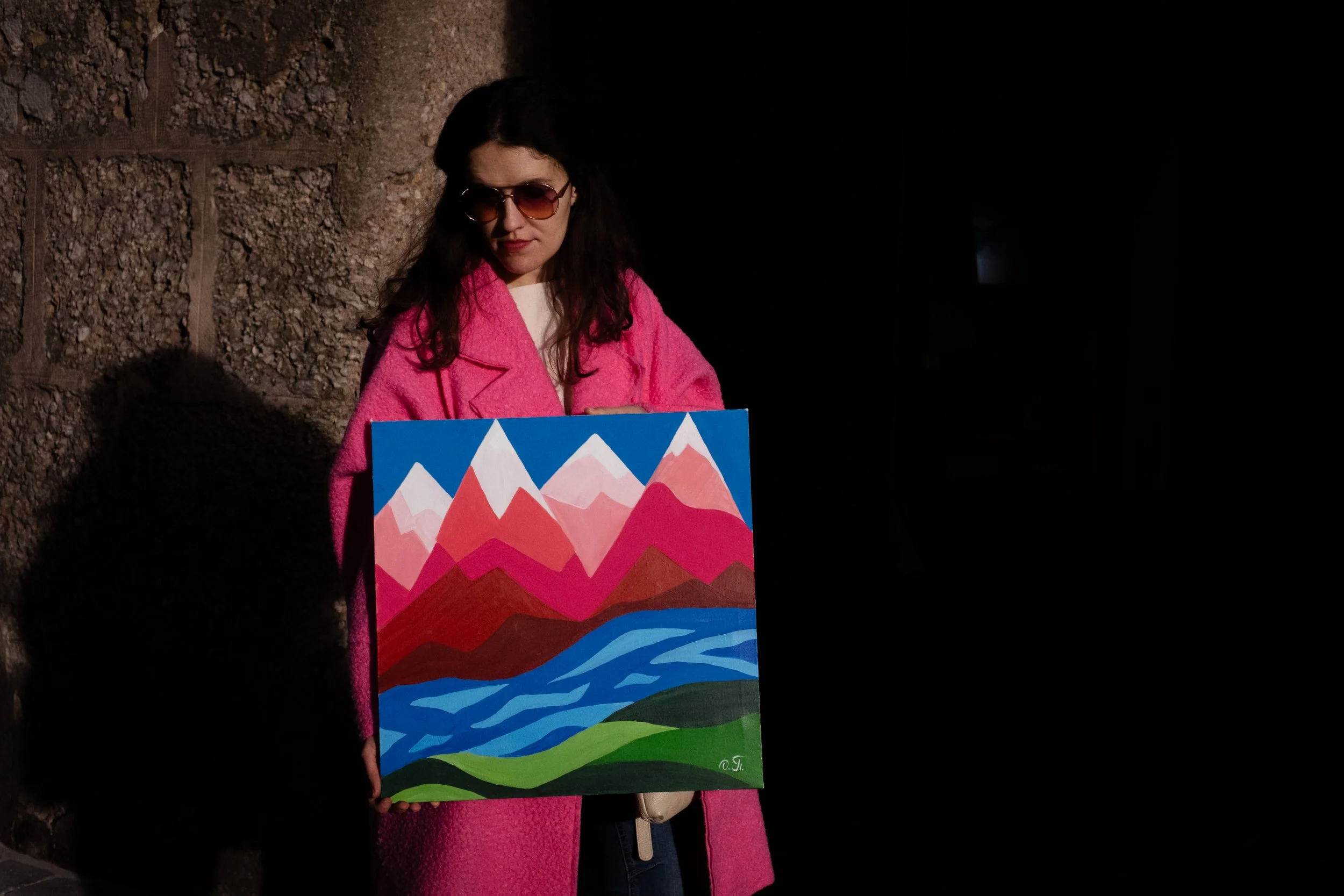 "Pink Mountains" by Oleksandra Roche-Newton, ORN art. Abstract acrylic painting of the Austrian Alps in Innsbruck at sunset, featuring pink and magenta mountain peaks with white snow caps, a blue river, and green hills.