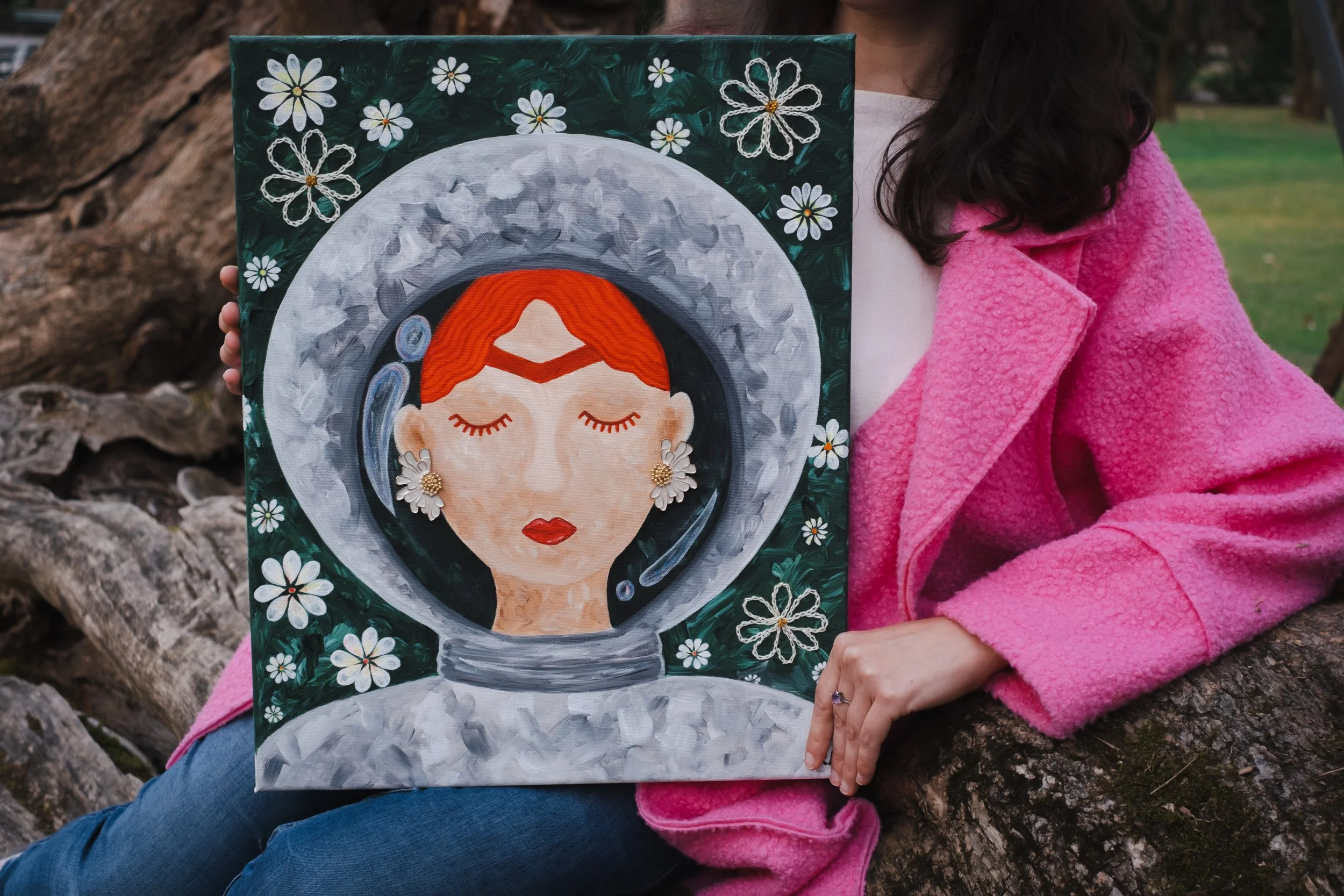 Acrylic painting of a female astronaut "Space Frida" with red hair and daisy earrings, surrounded by white flowers on a dark green background.