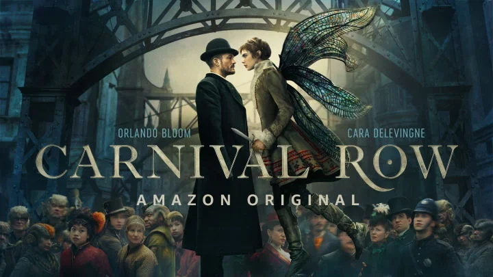 Promotional poster for the Amazon original series 'Carnival Row' featuring Orlando Bloom and Cara Delevingne in costume as fairy-like characters with large wings, standing on a bridge with a crowd of people dressed in 19th-century clothing below.