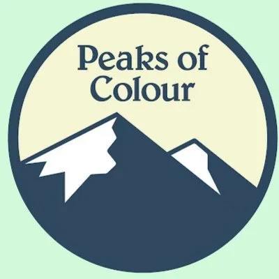 A circular logo featuring a stylized mountain range with the text 'Peaks of Colour' above it.