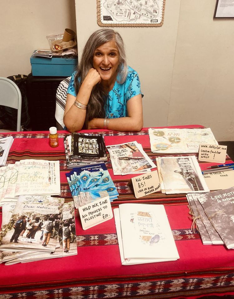 Dal with her zines at We've Got Food at Home! Zine Fest 2025. A collaboration with Over Here Zine Fest, Dal & Migration Matters.