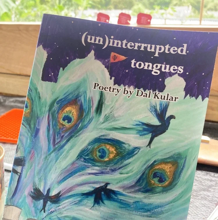 Cover of a poetry book titled '(un)interrupted tongues' by Dal Kular. The cover features an abstract illustration of vibrant peacock feather eyes against a background with shades of purple, blue, and white.