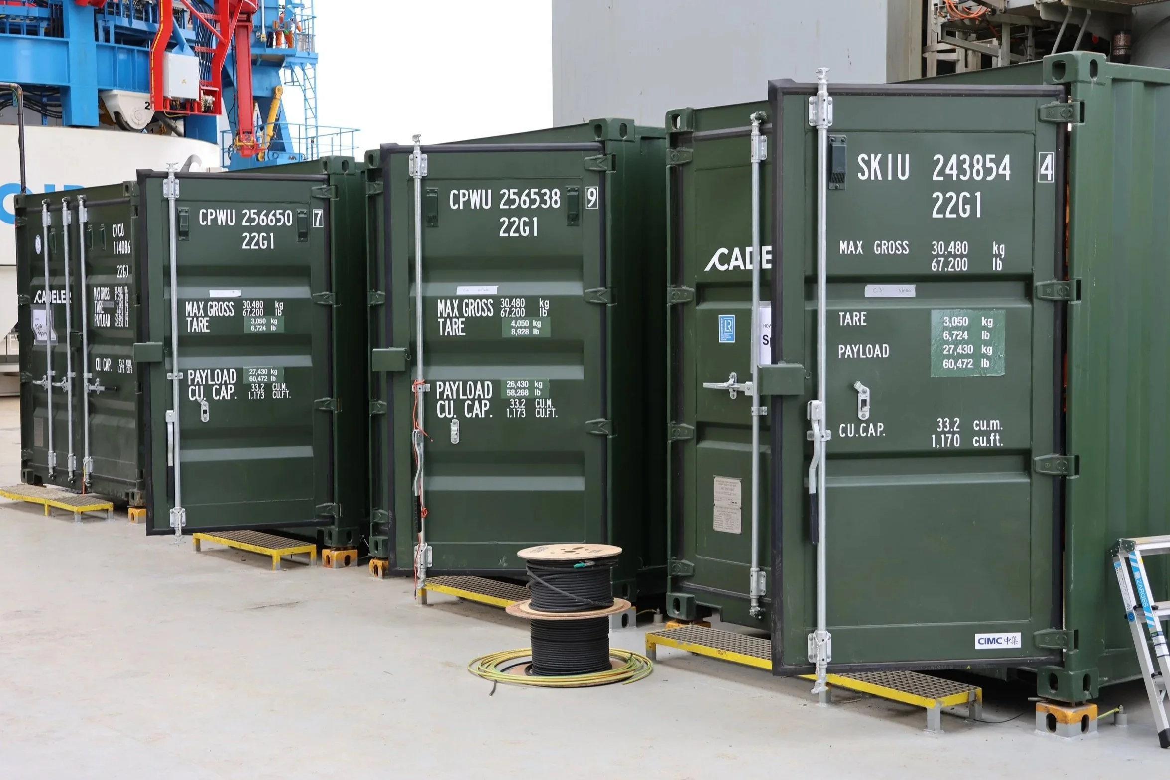 Four containers placed alongside aboard a vessel.