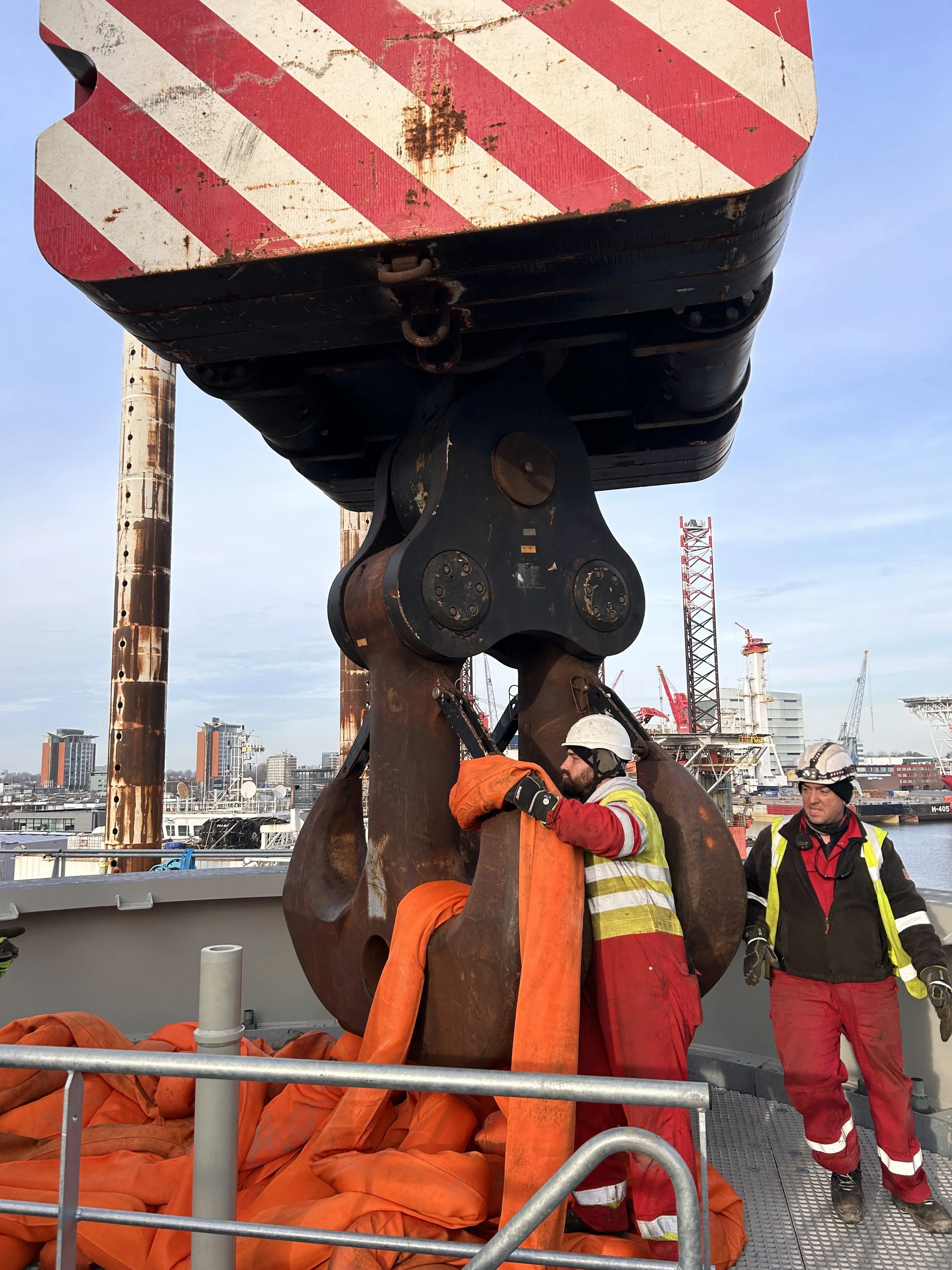 Riggers lift on large slings to crane hook