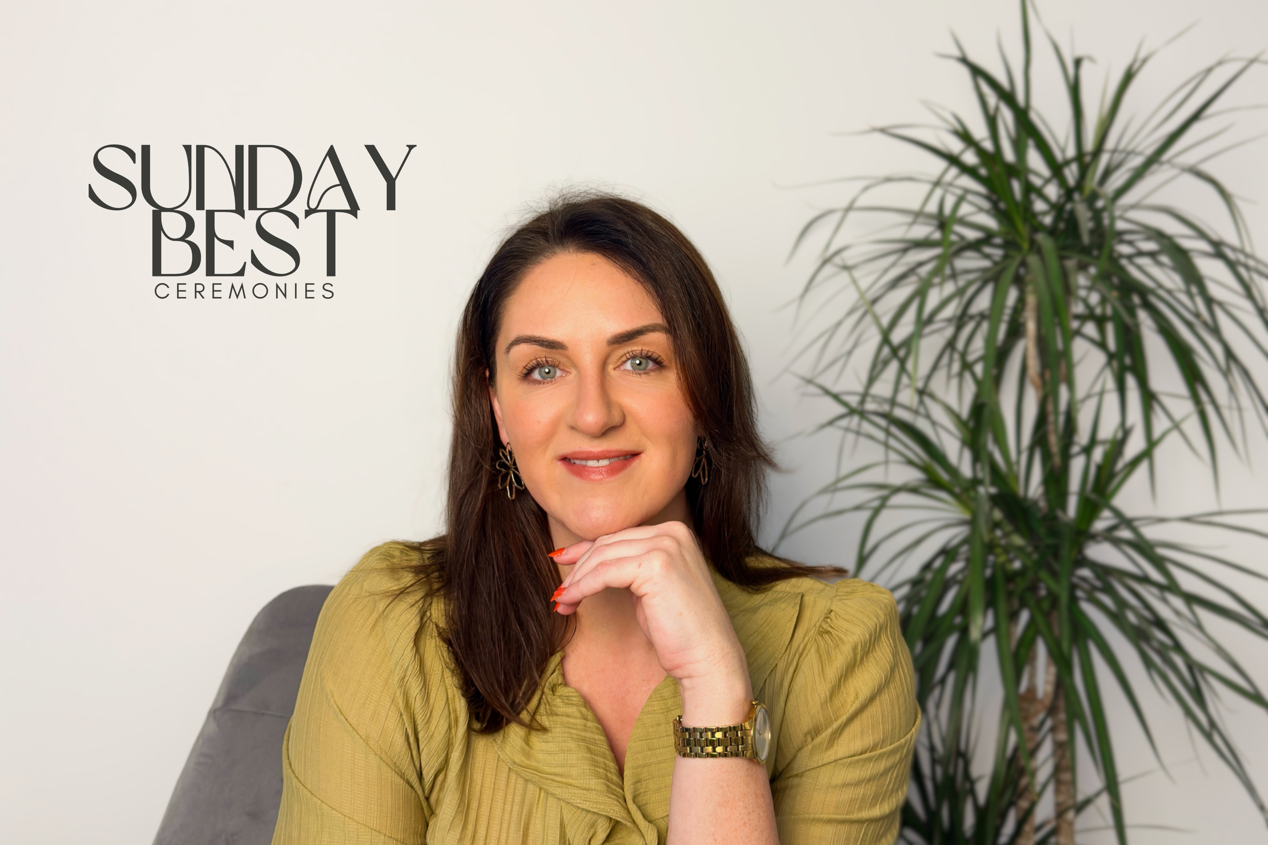 Portrait of Sarah Precious, wedding celebrant at Sunday Best Ceremonies, seated indoors with a calm, welcoming expression and a leafy plant in the background.