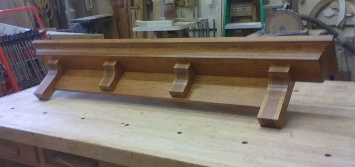 Wooden shelf with hooks on a workbench in a woodworking shop.