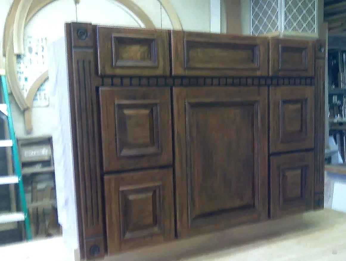 Wooden cabinet with raised panel doors in a workshop or storage area.