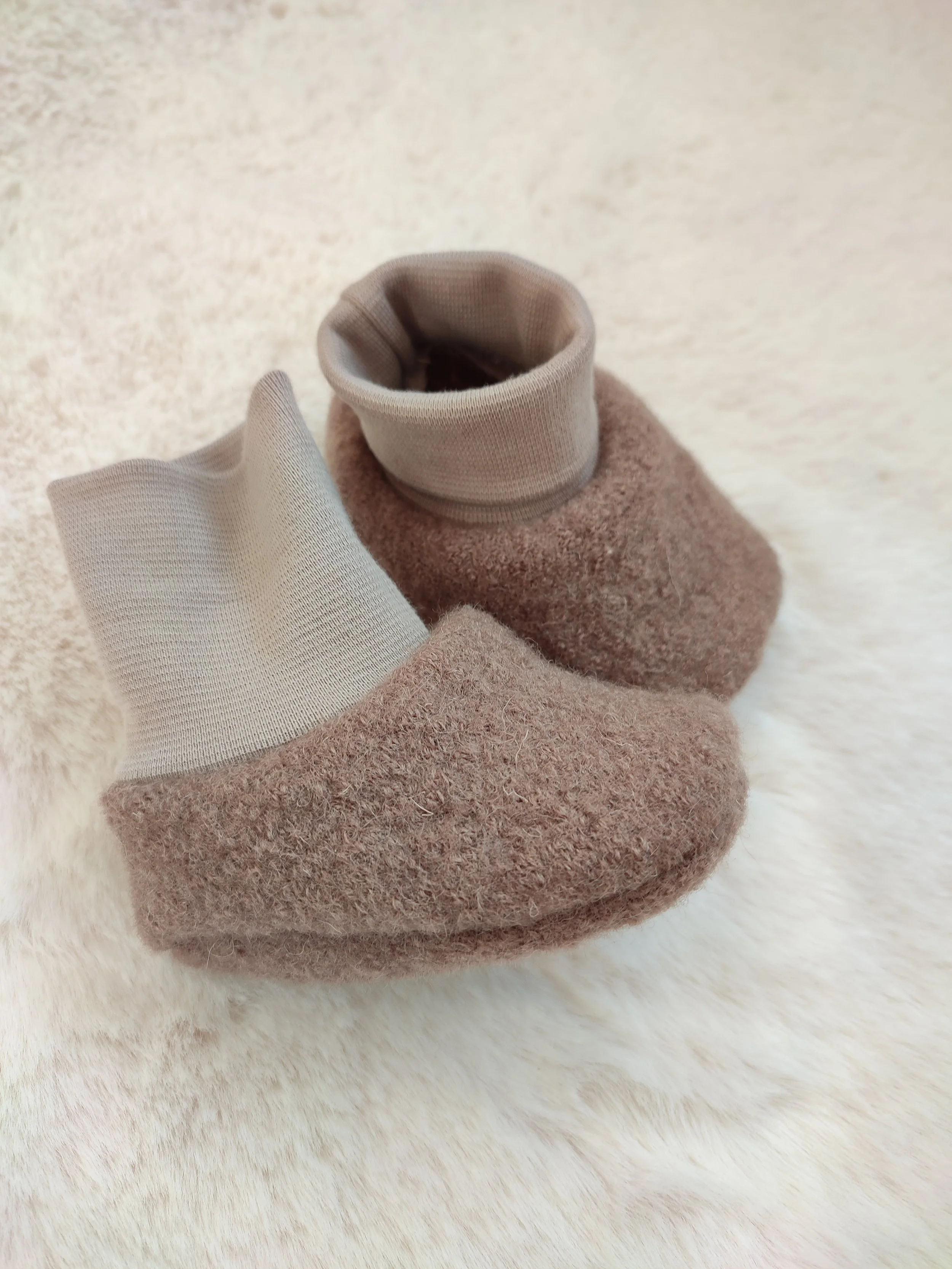 Babyschuh aus weichem, braunem Filzstoff mit elastischer, heller Spitze