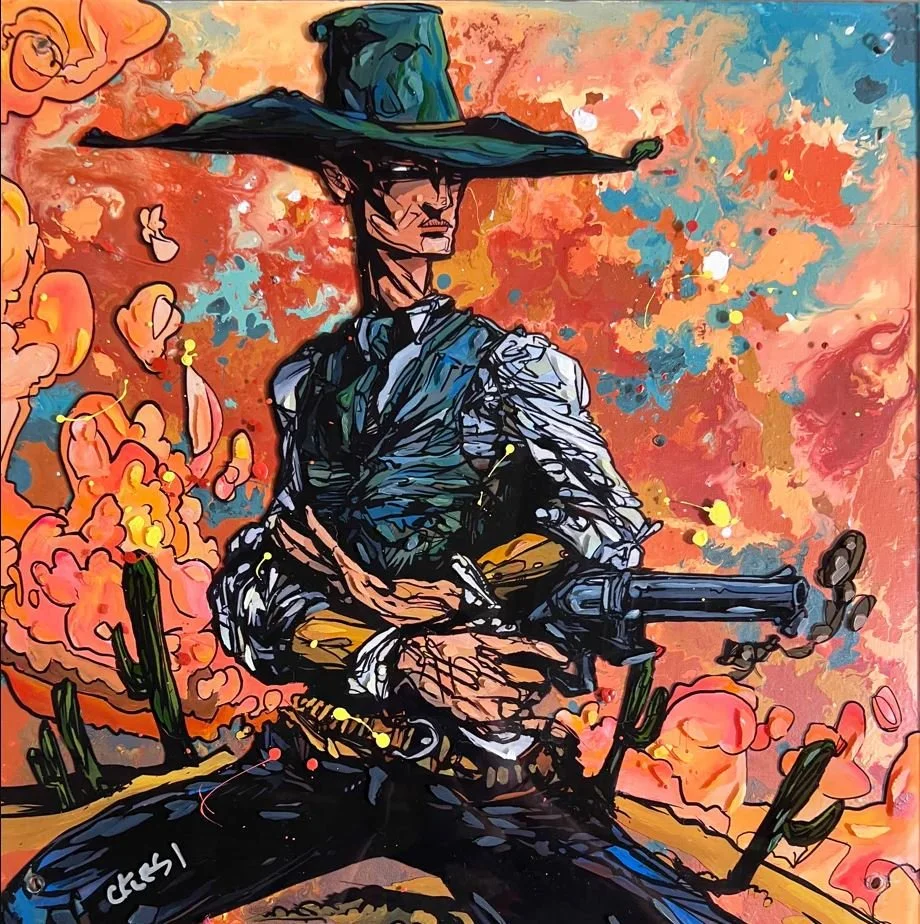 A colorful street art mural depicting a man in a hat and traditional Mexican attire holding a rifle in a desert scene with cacti and a vibrant orange and red sky.