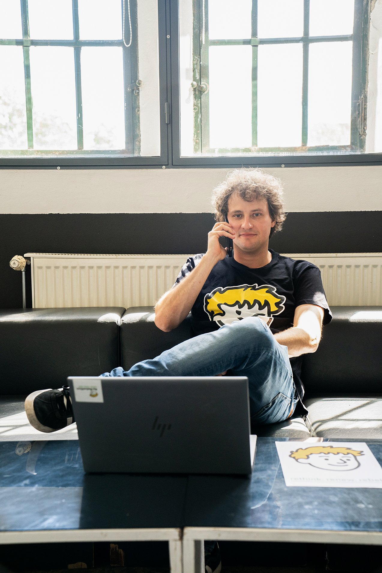 Michael Schmelcher from Re:Rebellion sits relaxed on his couch and talks on the phone with a customer.
