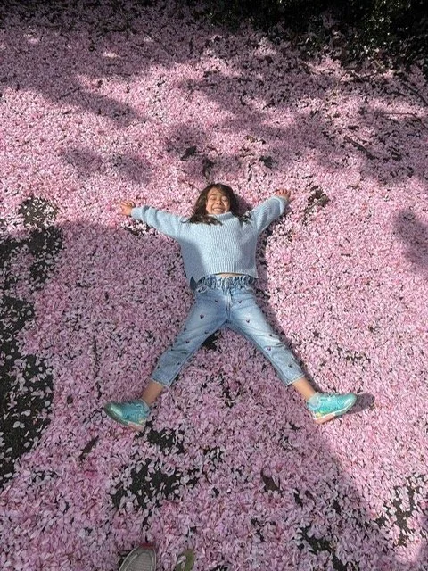 Child lying on pink blossoms