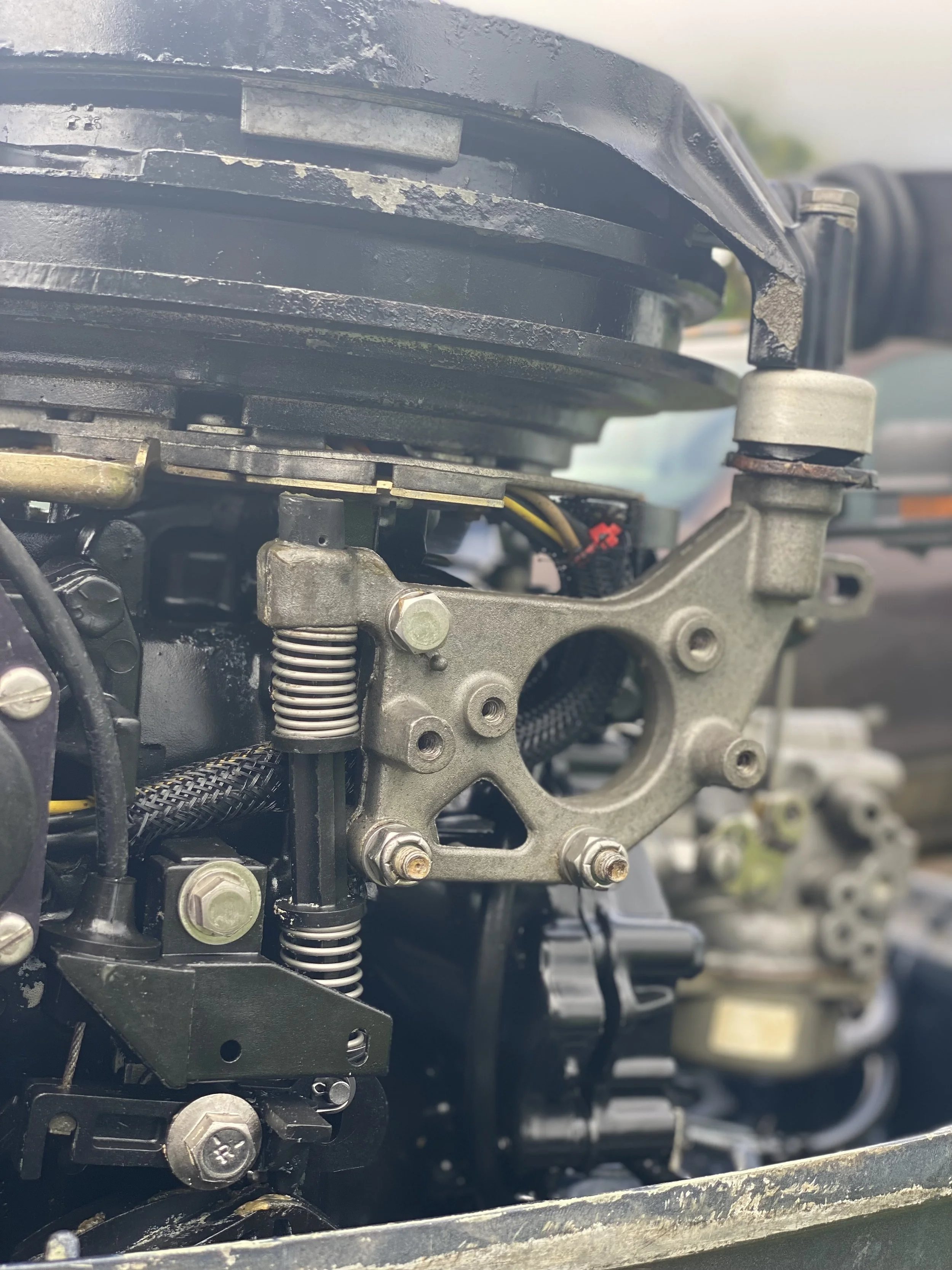 Close-up of a disassembled internal engine part with visible springs, bolts, and metal components.