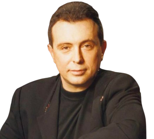 Porträt eines Mannes mit dunkler Jacke und schwarzem Hemd, lächelnd, vor dunklem Hintergrund.