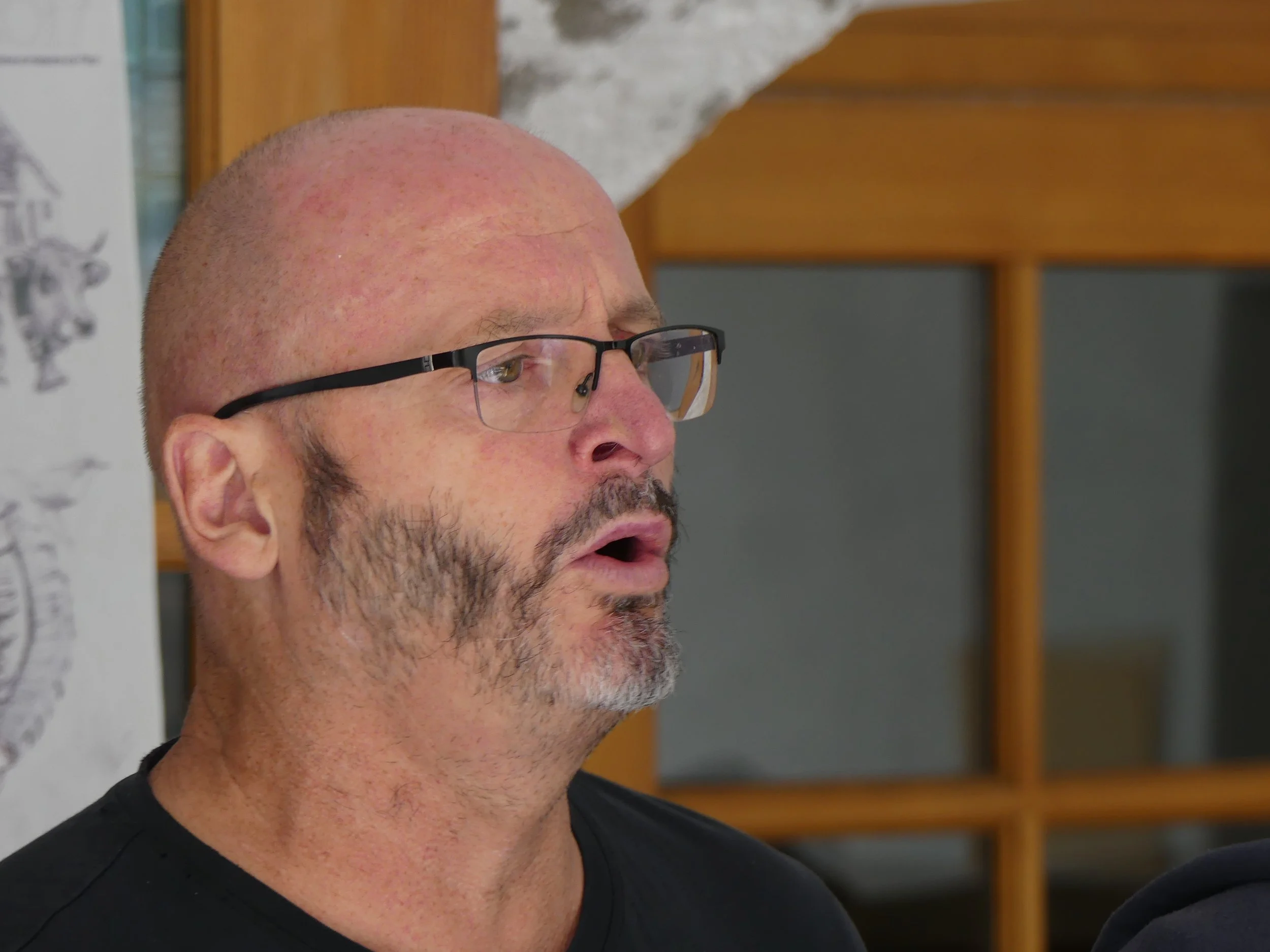 Homme avec lunettes et barbe, expression surprise ou impressionné, en intérieur