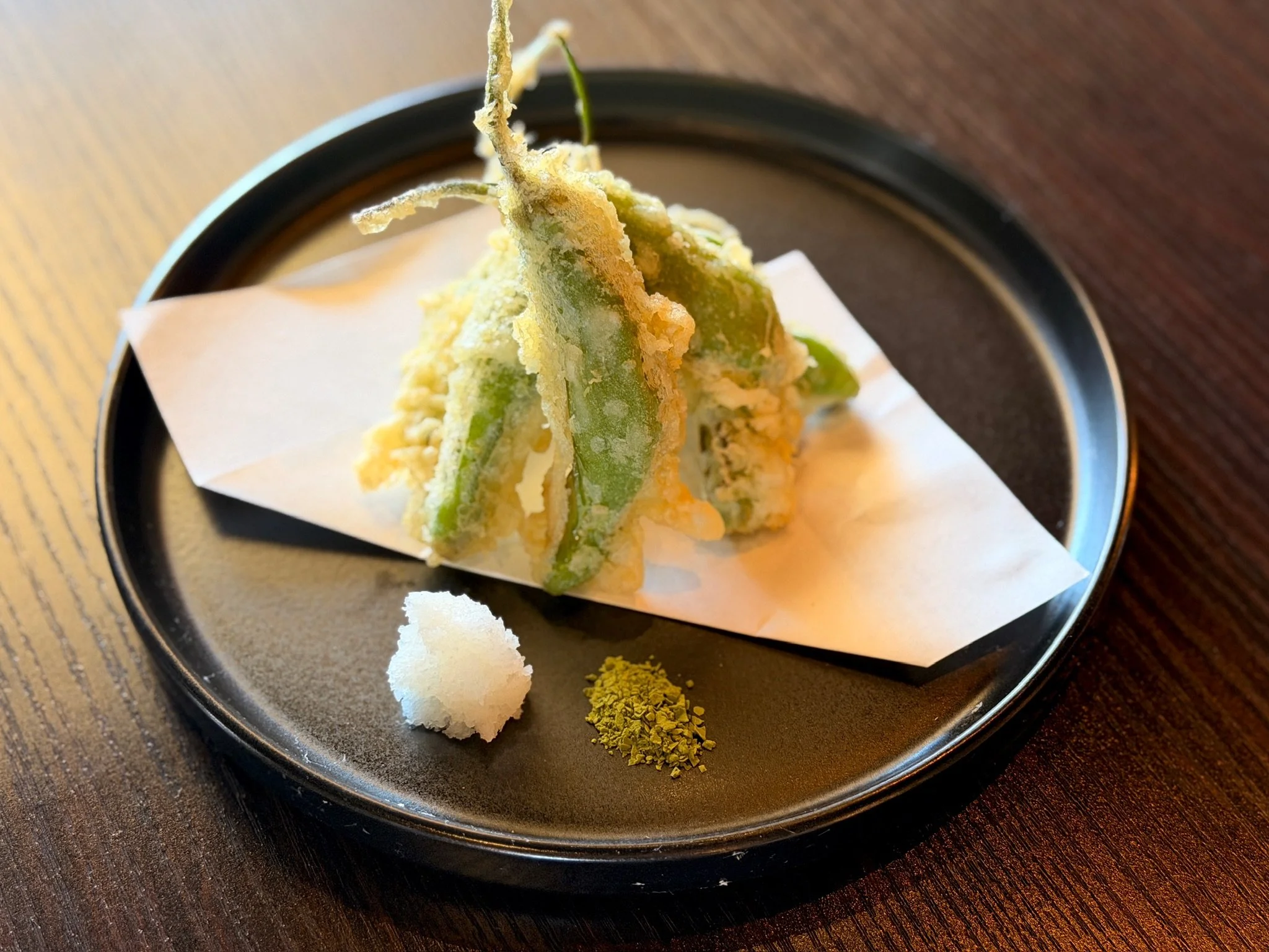 Shishito pepper tempura with grated daikon on a black plate at Nagisa Sushi, Point Loma