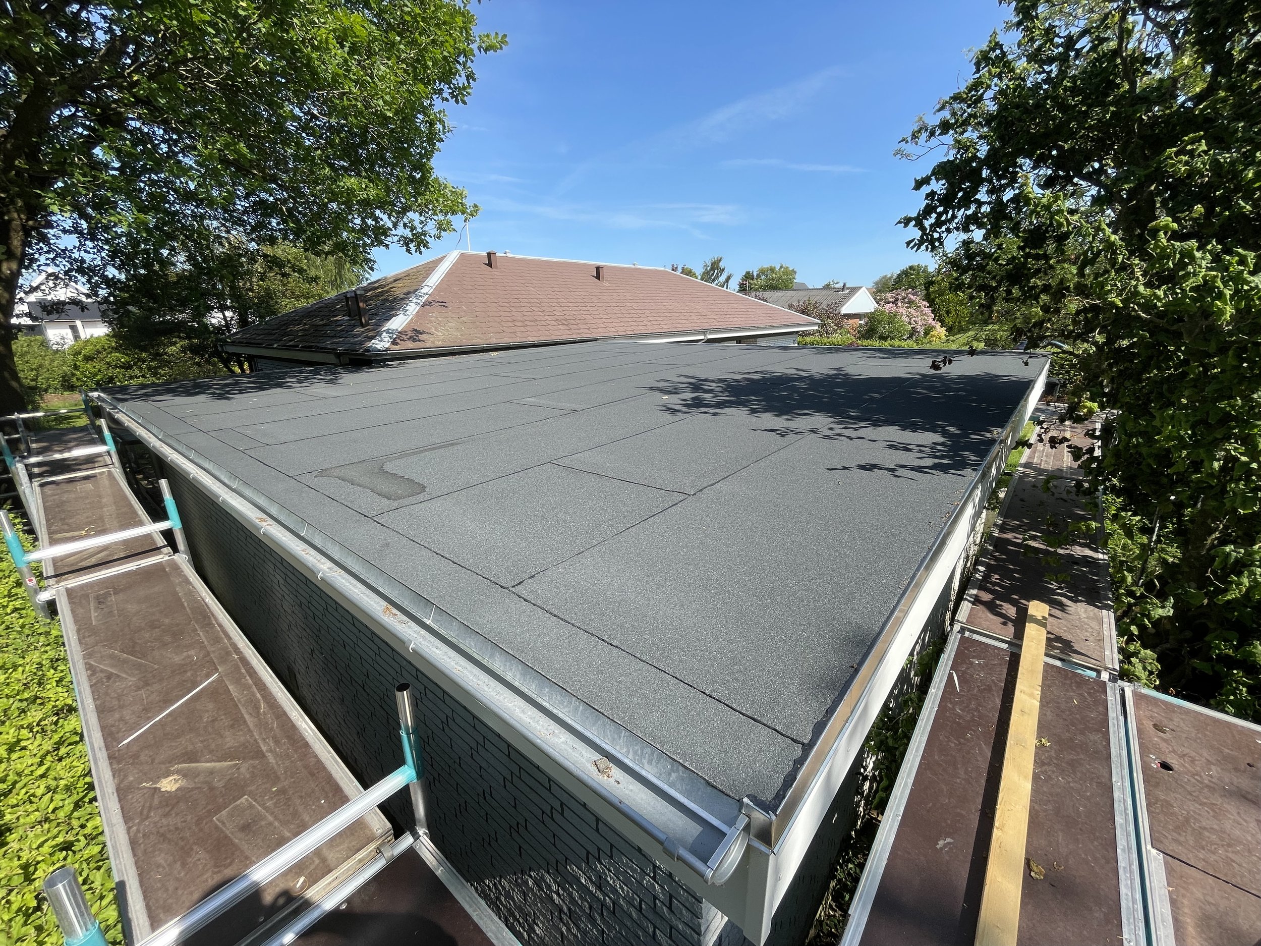 Et nyt tag med tagpap, set fra en stilling højt over taget.