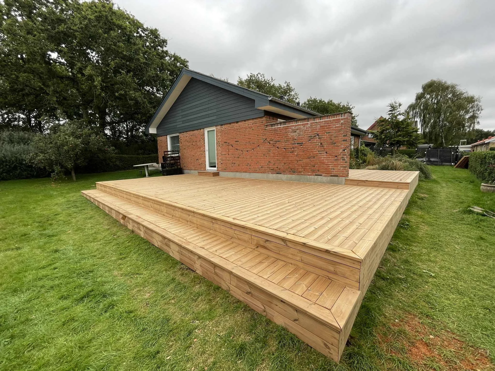 træterrasse med bænk og trin i thermo fyr