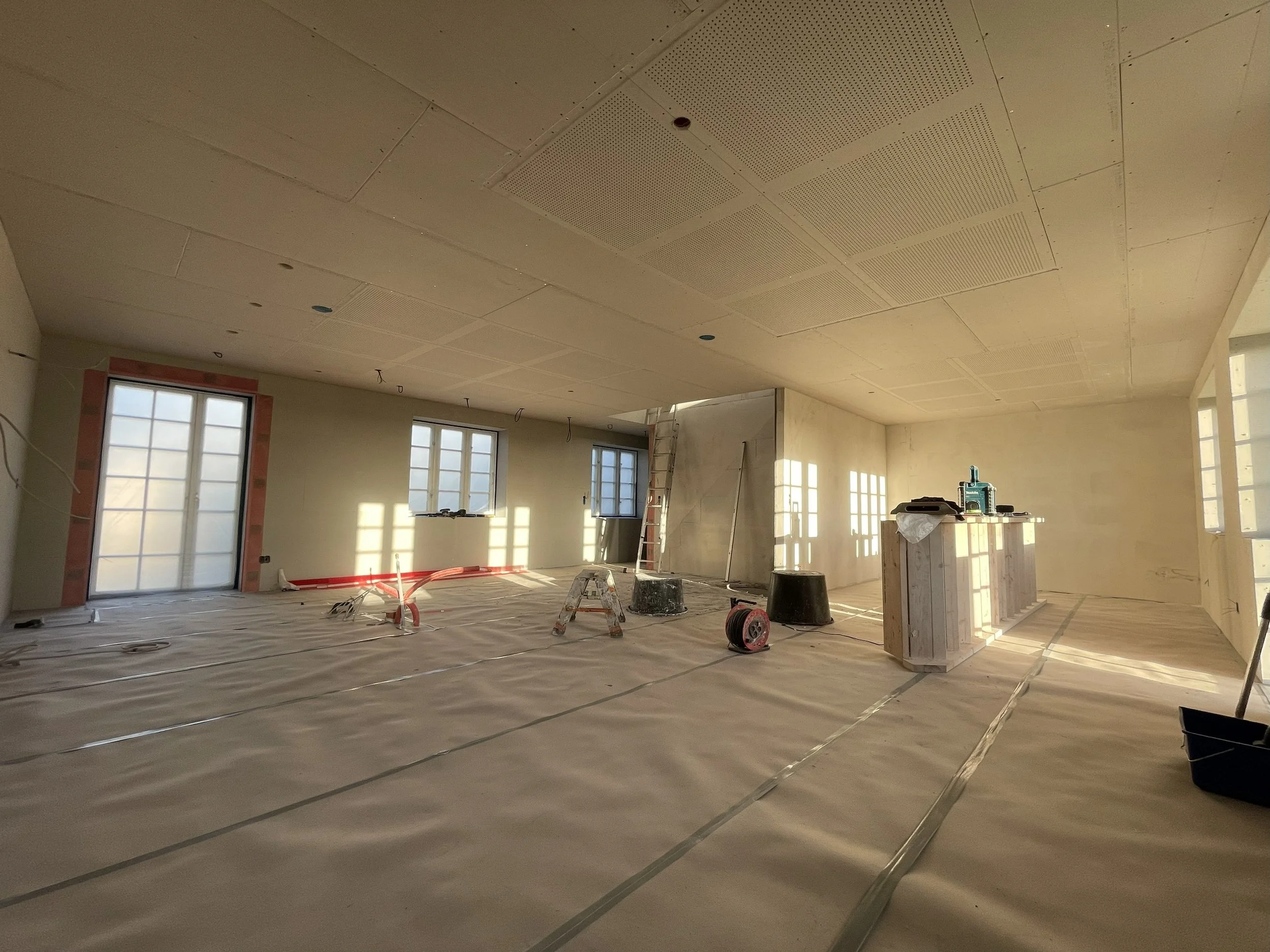 Indendørs byggeri eller renovering med udstyrede lofter, vinduer og Fermacell forsats vægge.