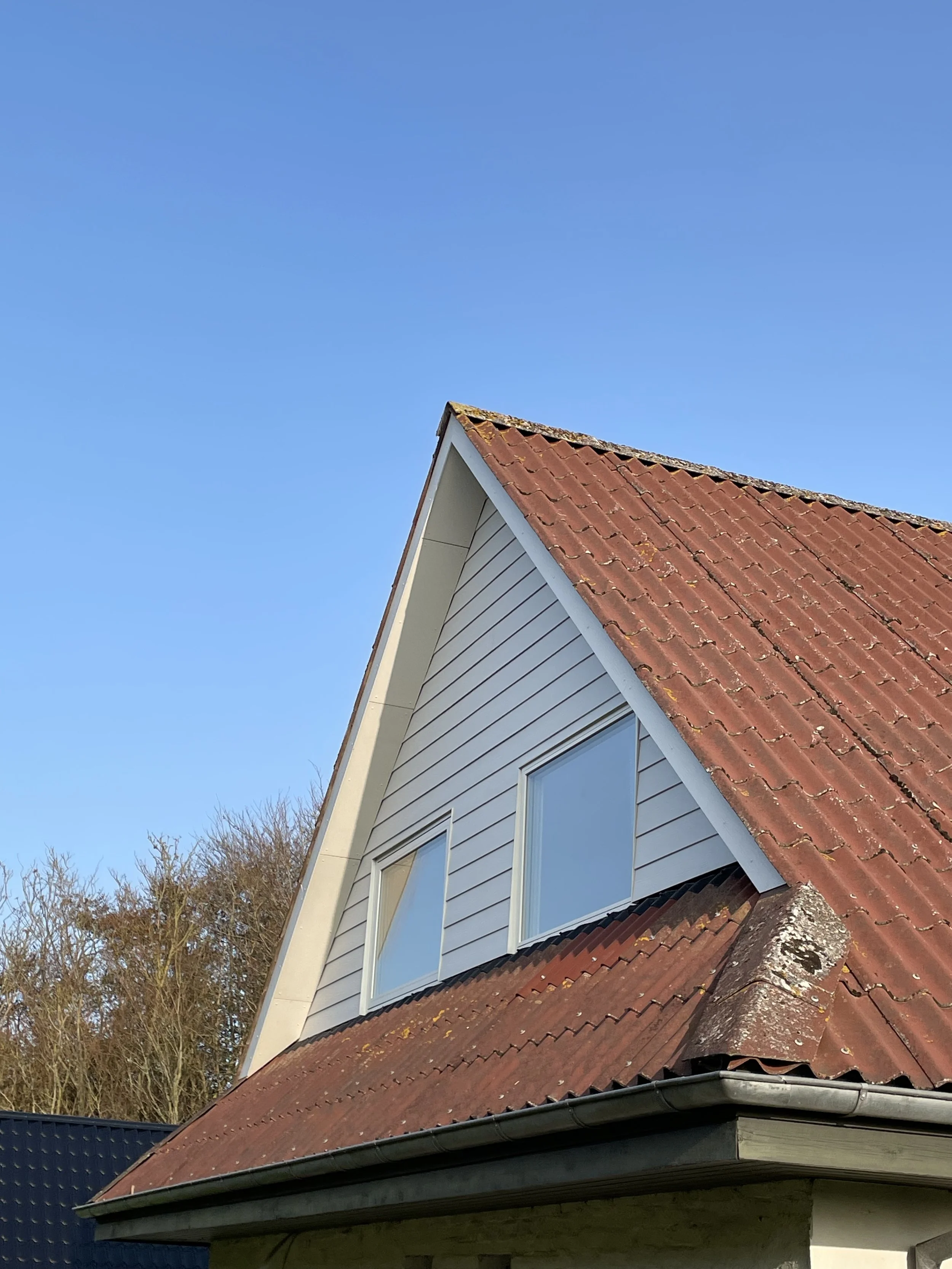 Færdig gavl med hvid hardieplank og rationel vinduer.
