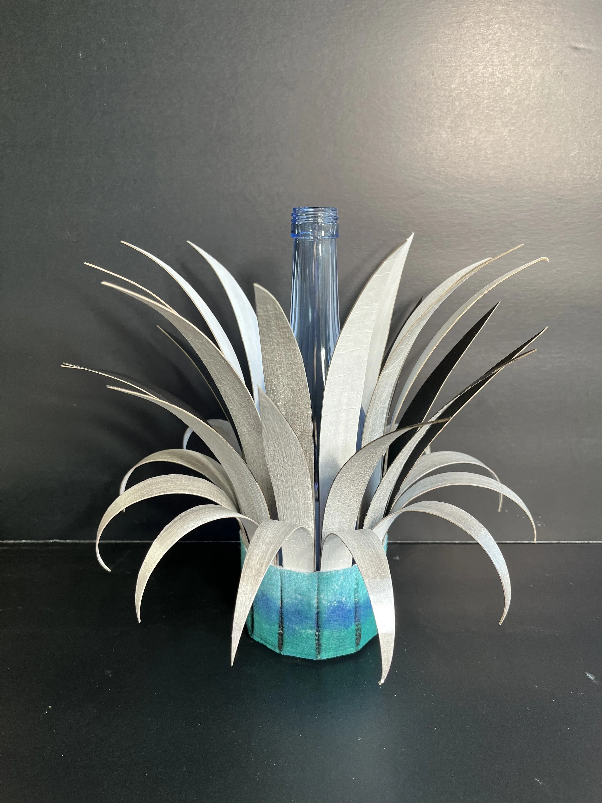 Bottle Crown:  Transparent Blue Bottle with Silver and Black Spikes; Blue with Black base.