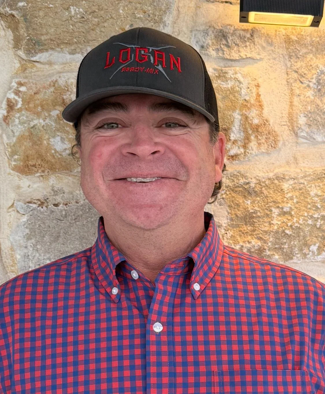 Business card for Logan Ready-Mix featuring a gray textured background, a logo with a gray spade symbol and red bold text saying 'LOGAN' and 'READY-MIX' in red, with contact information for Bucky McLeod, including phone numbers, email addresses, and a physical address in Bridgeport, Texas.