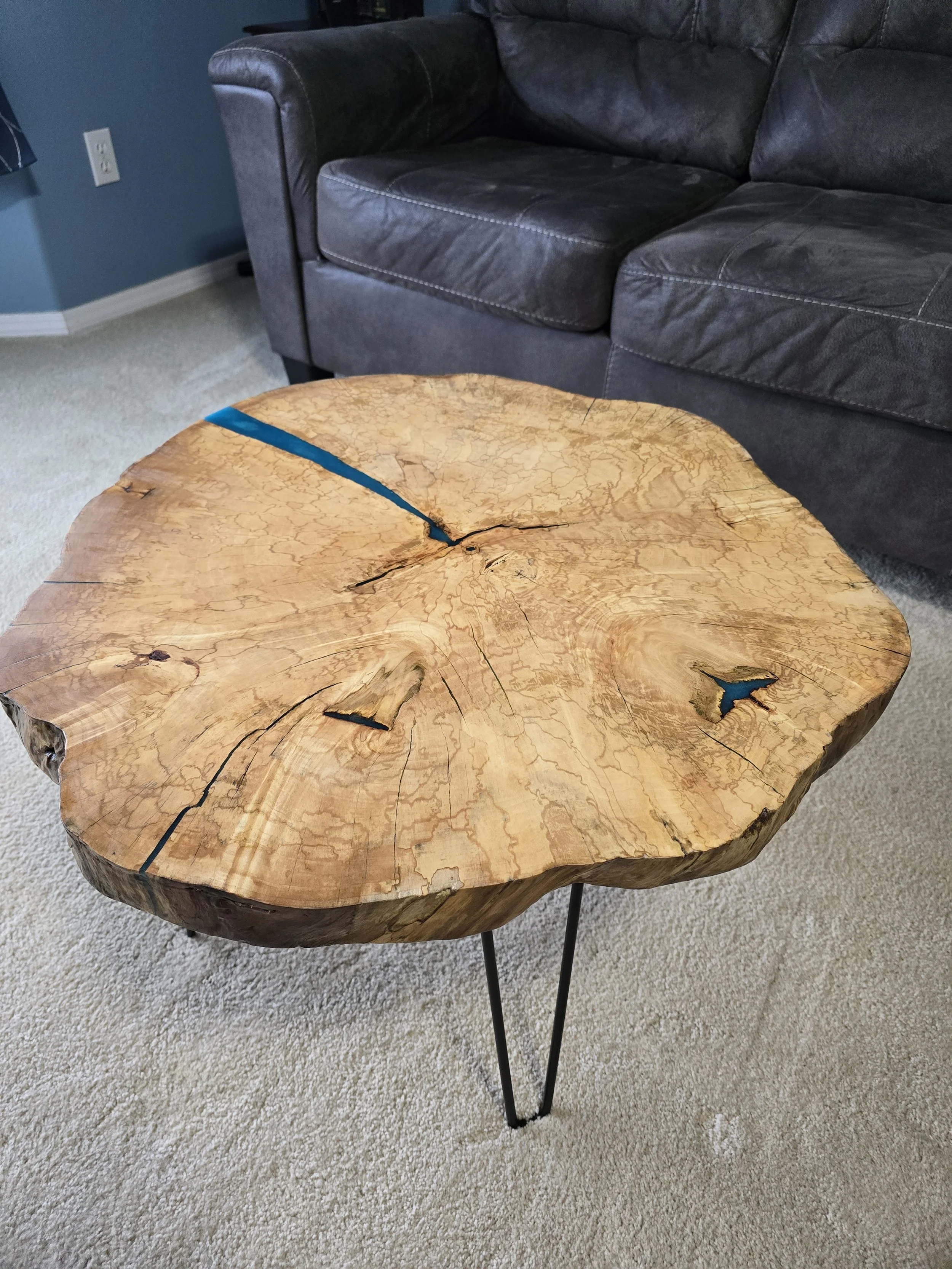 This table is made from maple and measures 18 inches tall and 26 inches across. it stands on hairpin legs.