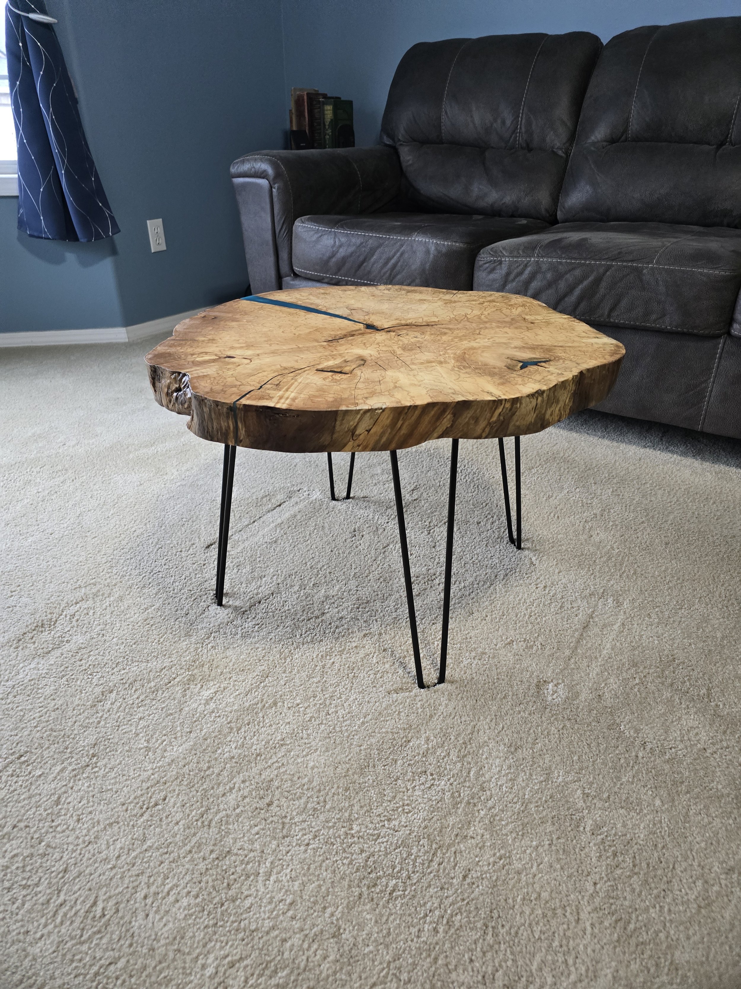 This table is made from maple and measures 18 inches tall and 26 inches across. it stands on hairpin legs.