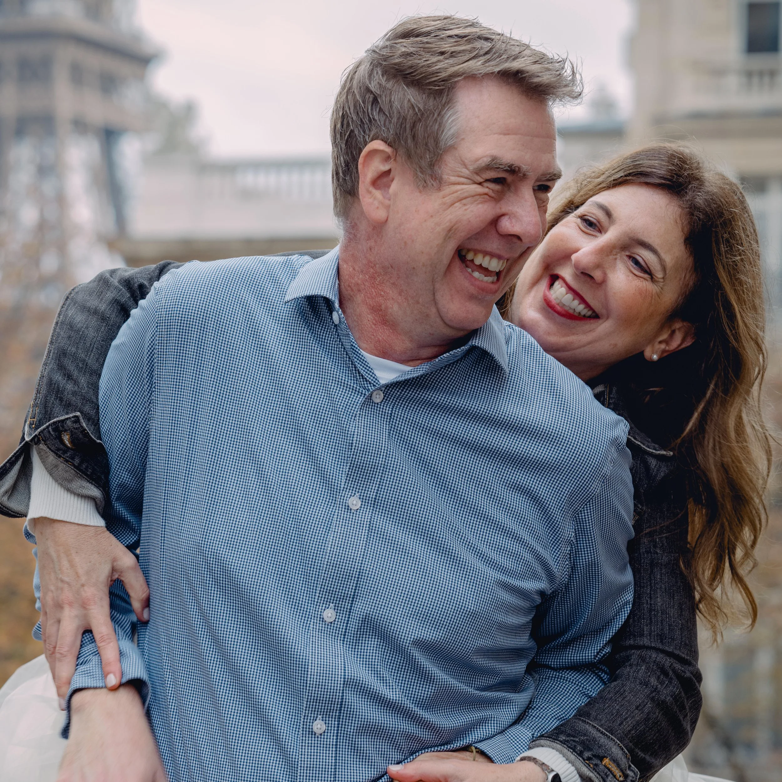 A happy couple embracing outdoors, smiling and laughing together.