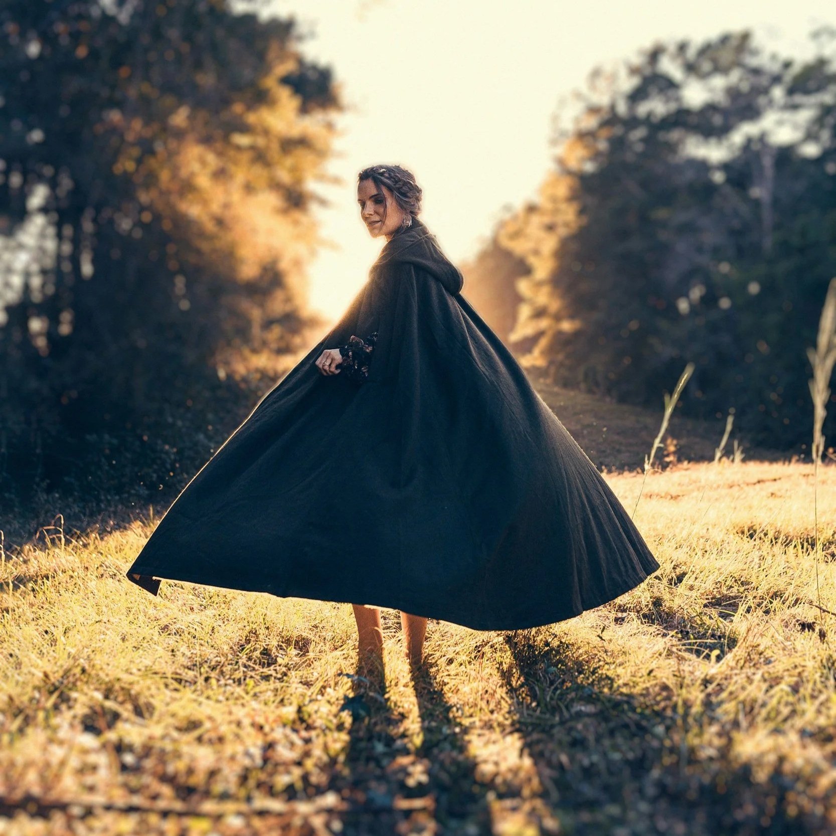 Woman wearing a cloak in a beautiful field.