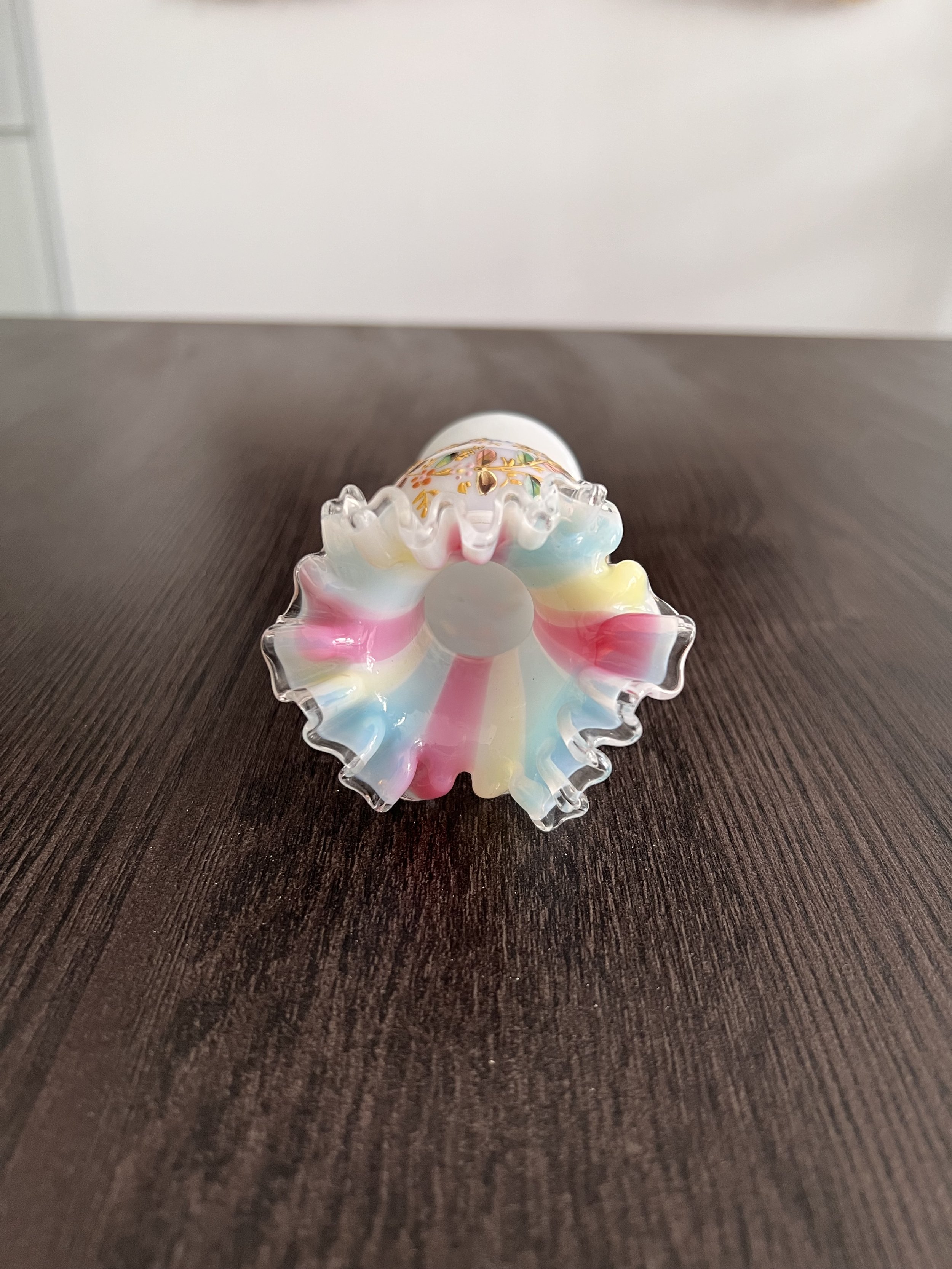 Small French white opaline glass vase with hand-painted floral enamel decoration, gilt accents, and pastel ruffled rim, circa 1900.