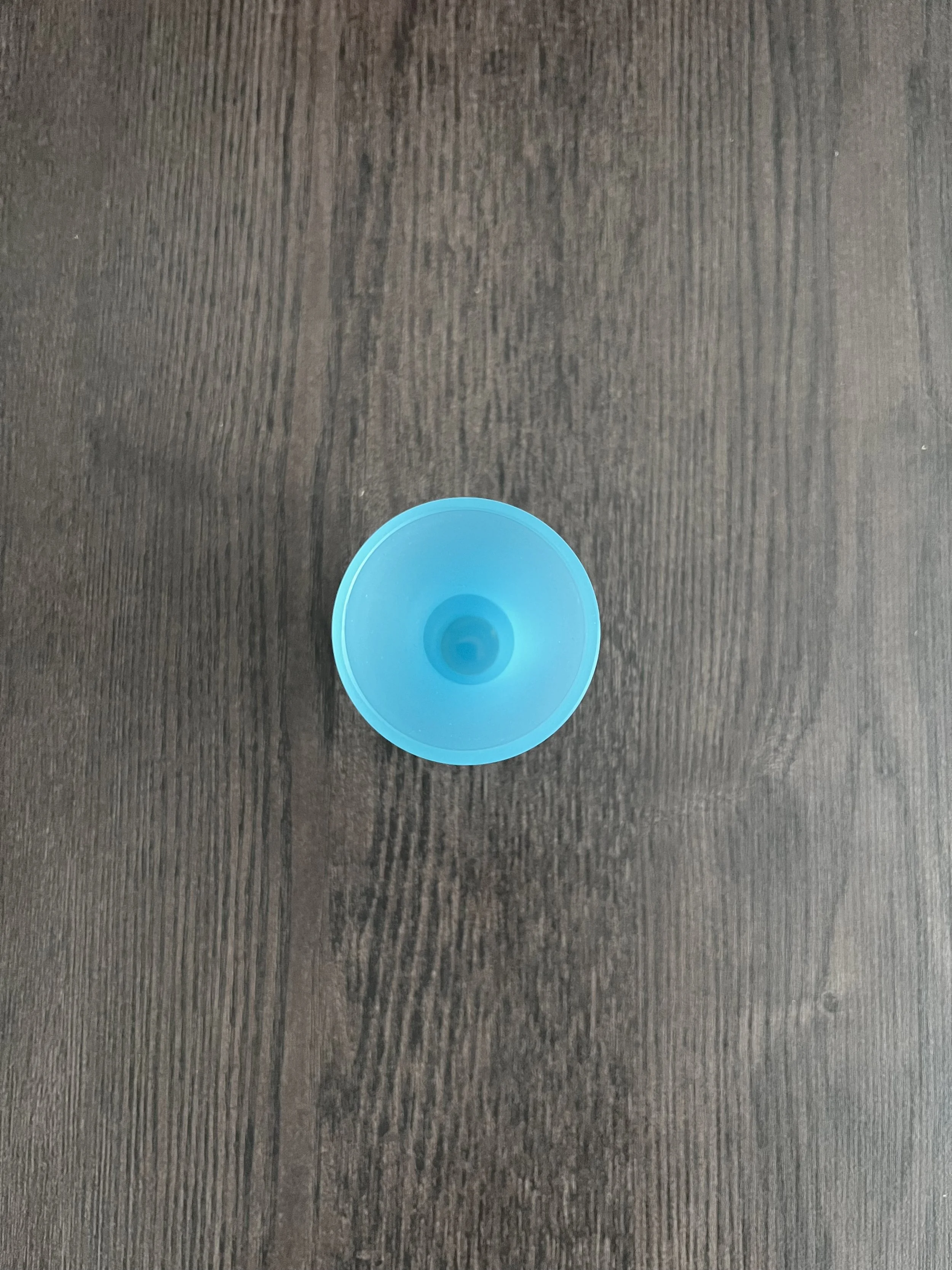 Small mid-century vintage baby blue opaline glass vase with a flared trumpet neck, bulbous spherical base, and short pedestal foot, displayed on a dark wooden table background.
